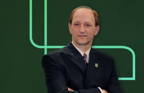 Foto do Vitor de braços cruzados com o P envolvendo o colaborador